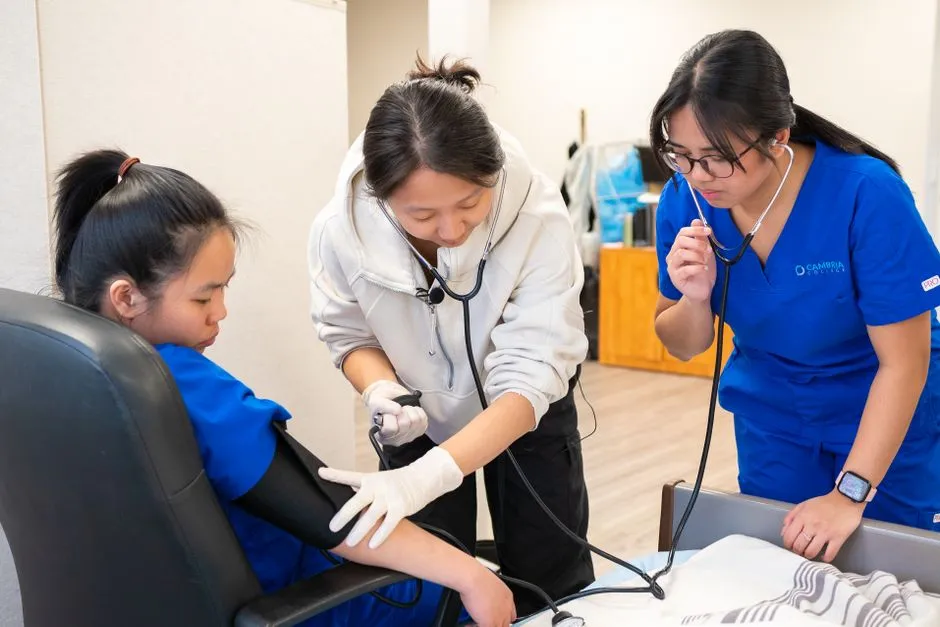 Nursing students practicing blood pressure measurement in a training lab